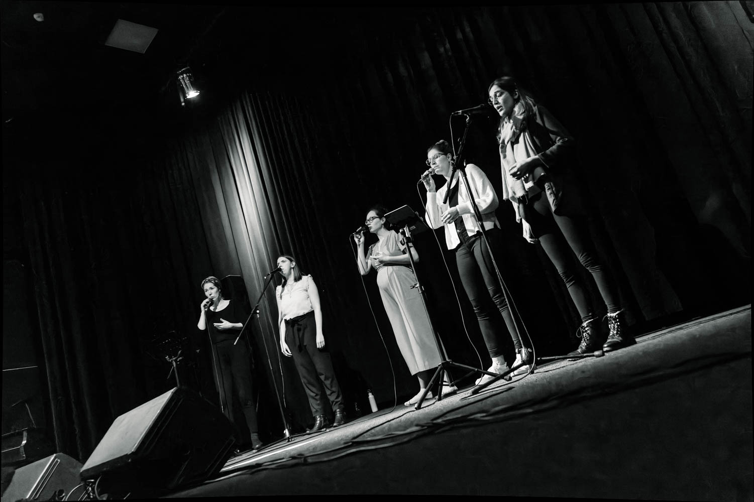 Bild mit Schwarzweißeffekt: Die A-cappella-Gruppe "mata" steht bei einem Auftritt auf der Bühne
